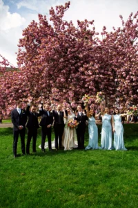 Bride and wedding party celebrating under blooming cherry blossoms