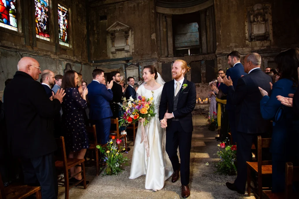 Bride and groom walking hand in hand down the aisle