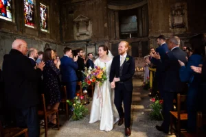 Bride and groom walking hand in hand down the aisle