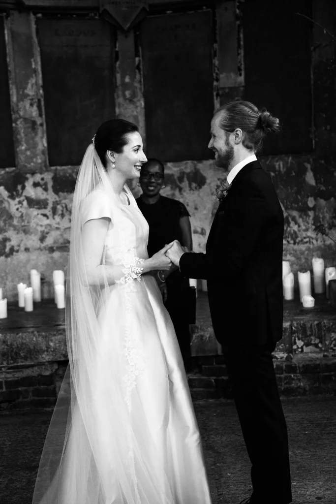 Bride and groom exchanging vows with candles and floral decor