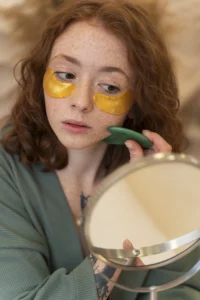 Bride-to-be applying golden under-eye patches as part of her pre-wedding beauty routine.