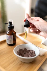 Applying nourishing oil into clay mask for frizzy hair salon treatment