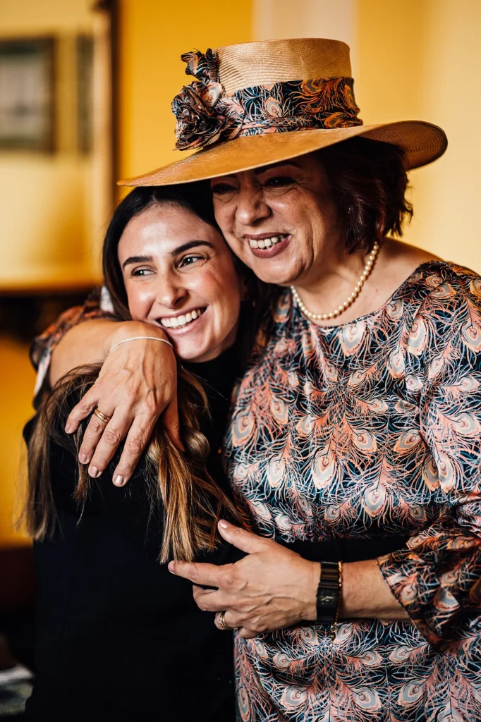 Two women hugging warmly before wedding celebration
