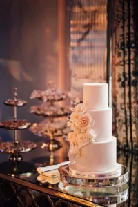 Three-tiered white wedding cake decorated with roses