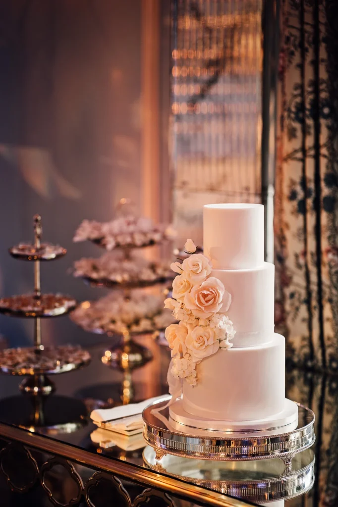 Three-tiered white wedding cake decorated with roses