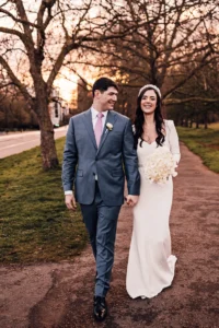 Just married couple walking down a tree-lined path during golden hour