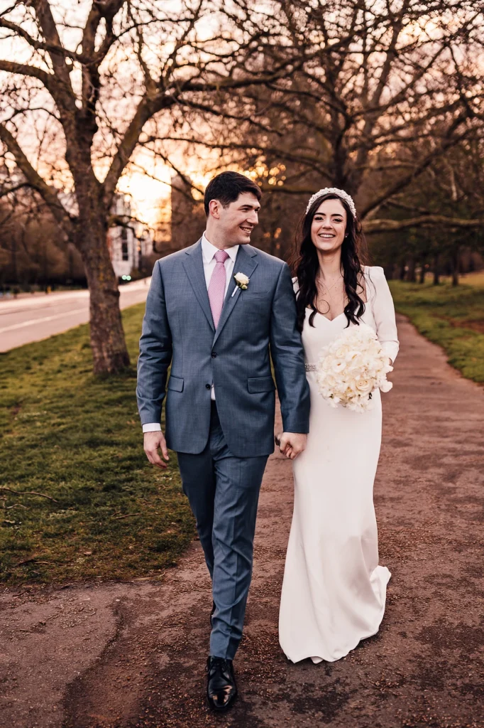 Just married couple walking down a tree-lined path during golden hour