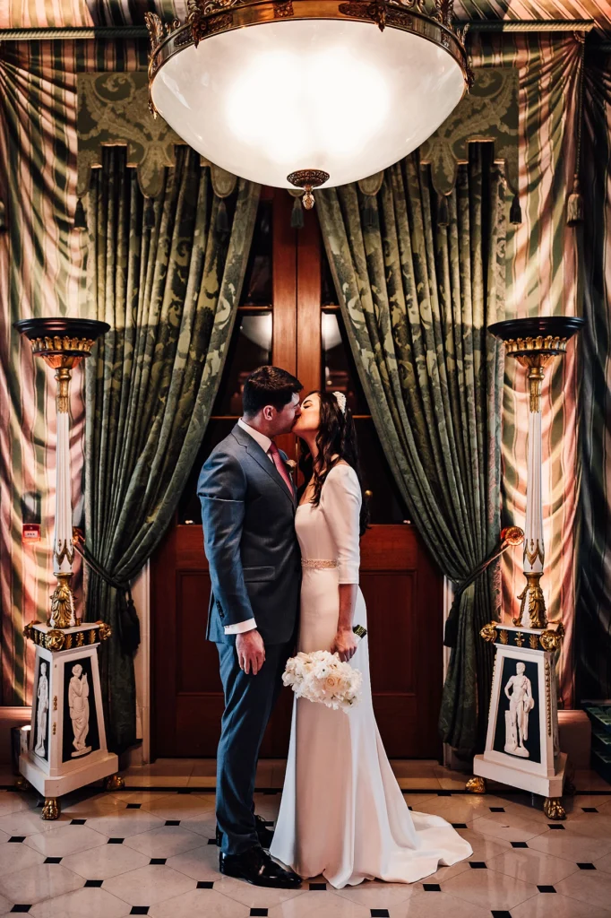 Bride and groom sharing a kiss under chandelier at The Lanesborough