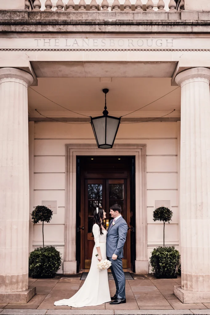 Couple standing together outside the grand entrance of The Lanesborough