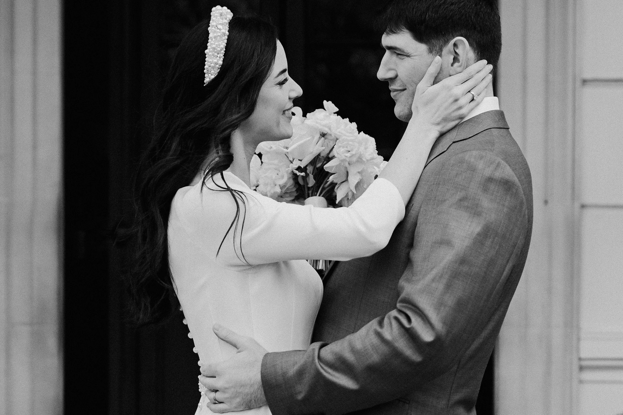 Close-up of bride smiling at groom while holding flowers