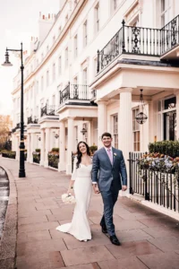 Happy bride and groom walking along the pavement