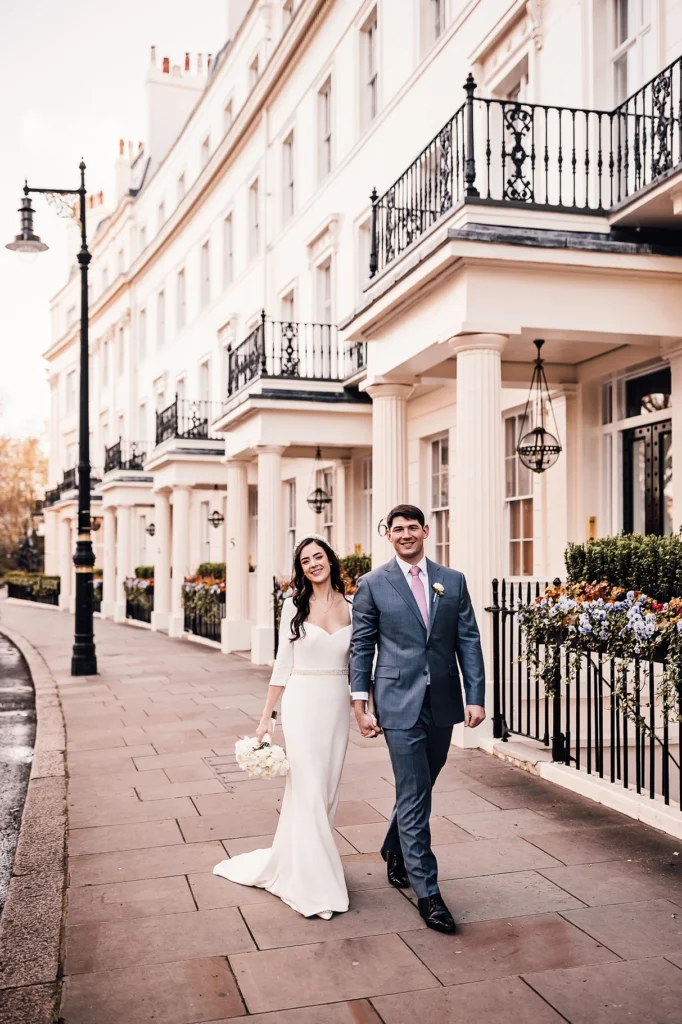 Happy bride and groom walking along the pavement