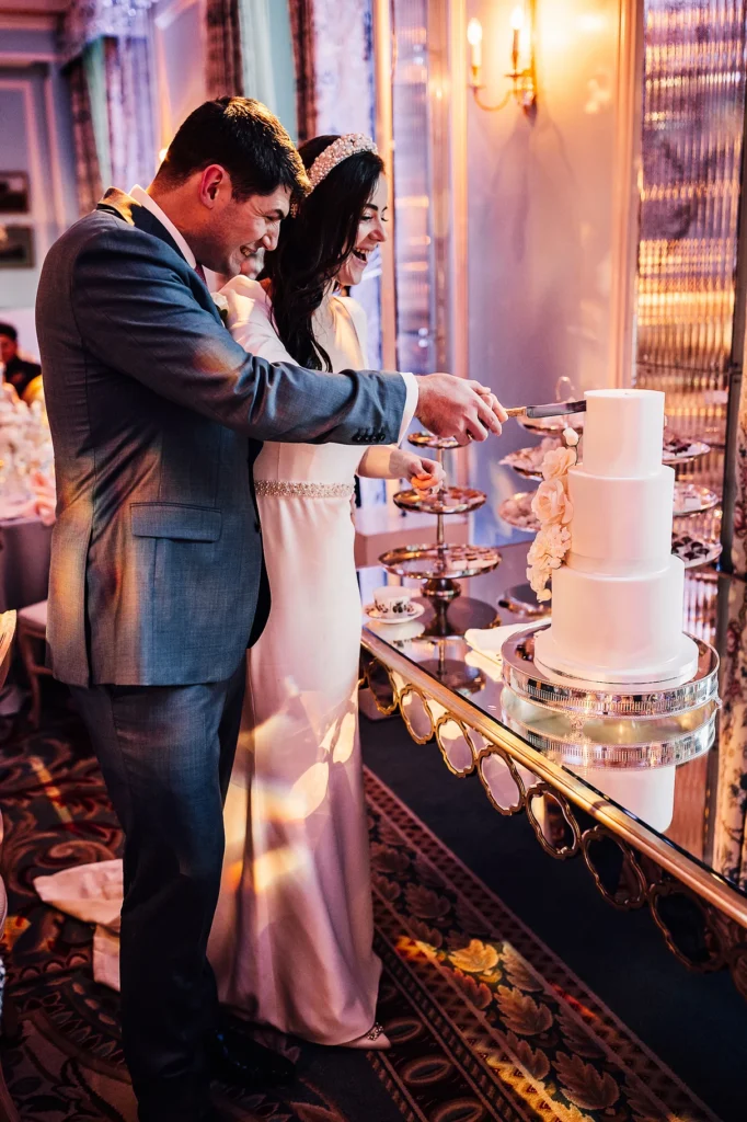 Bride and groom cutting their elegant three-tier wedding cake