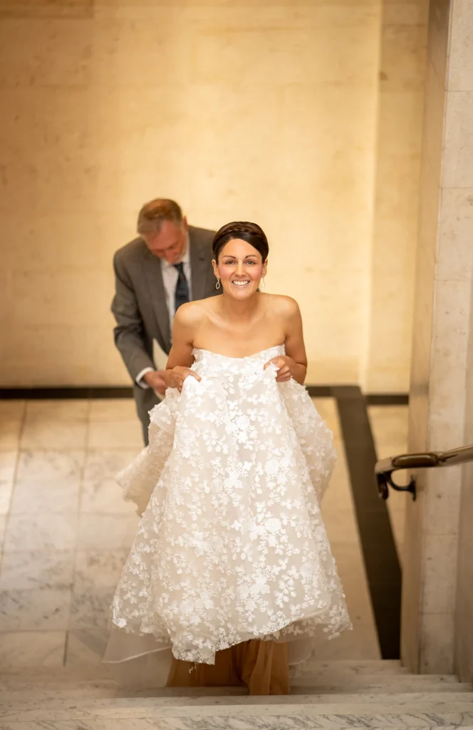 Smiling bride walking up the stairs inside wedding venue