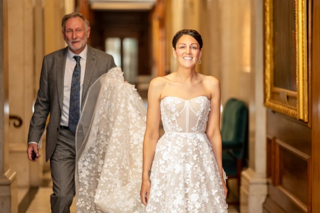 Bride walking with father in corridor before the wedding