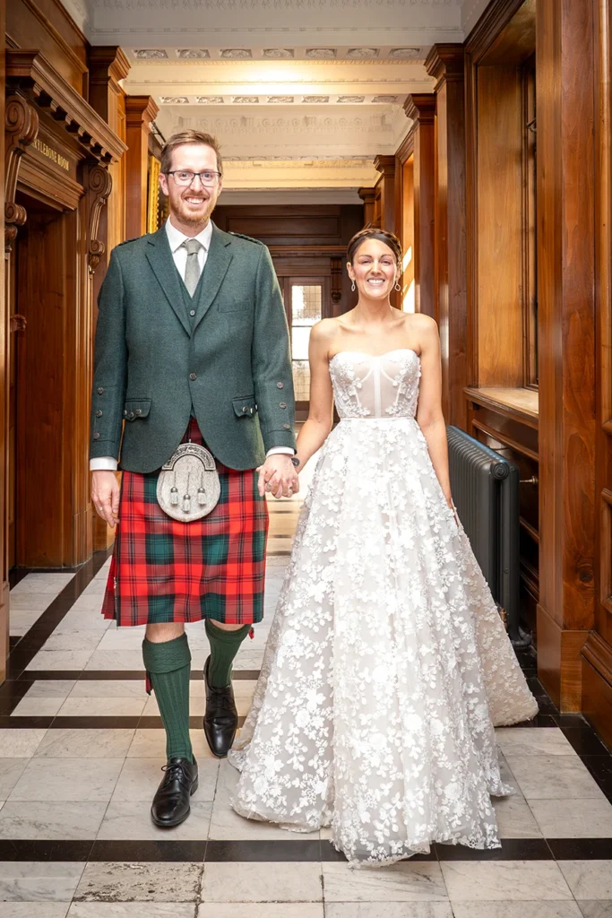 Bride and groom smiling and walking hand in hand