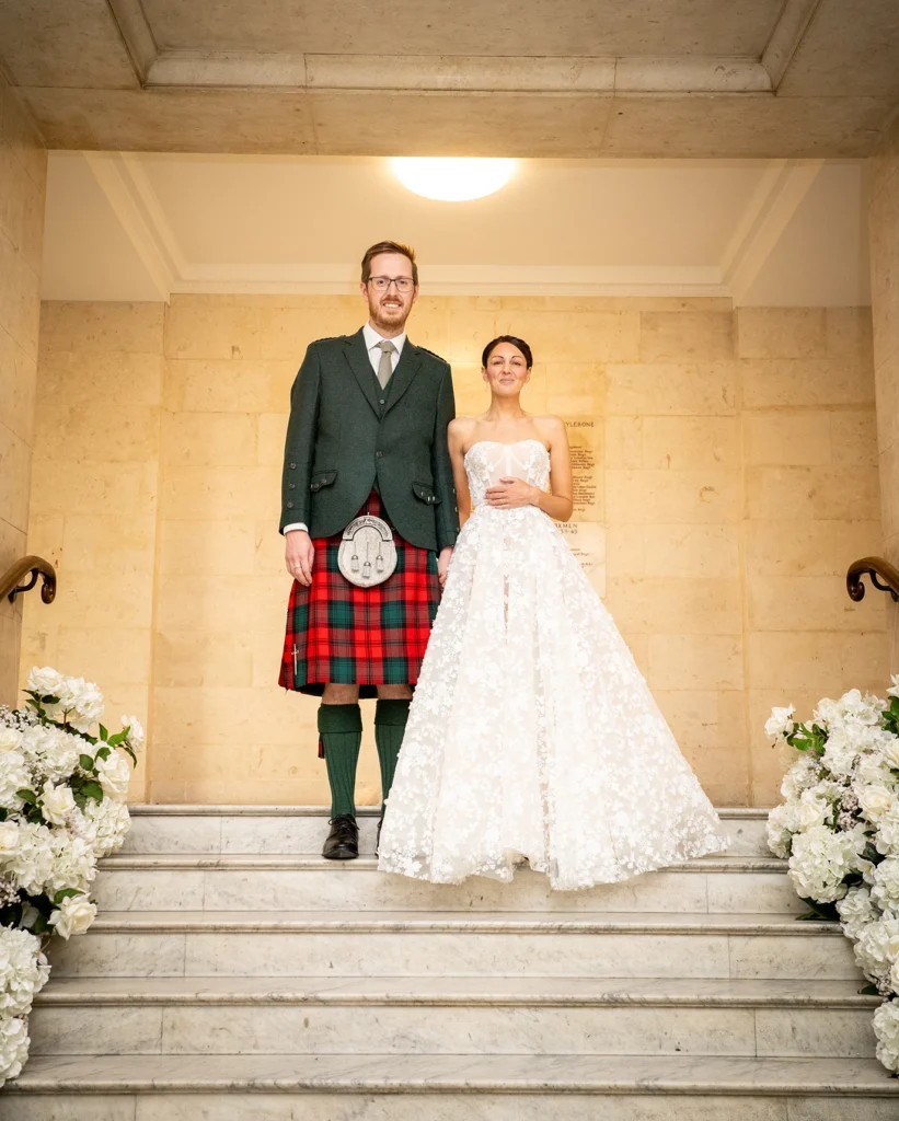 Wedding couple standing at the top of decorated stairs