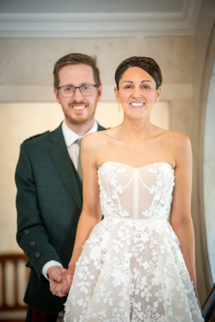 Close-up of bride smiling with groom standing behind her
