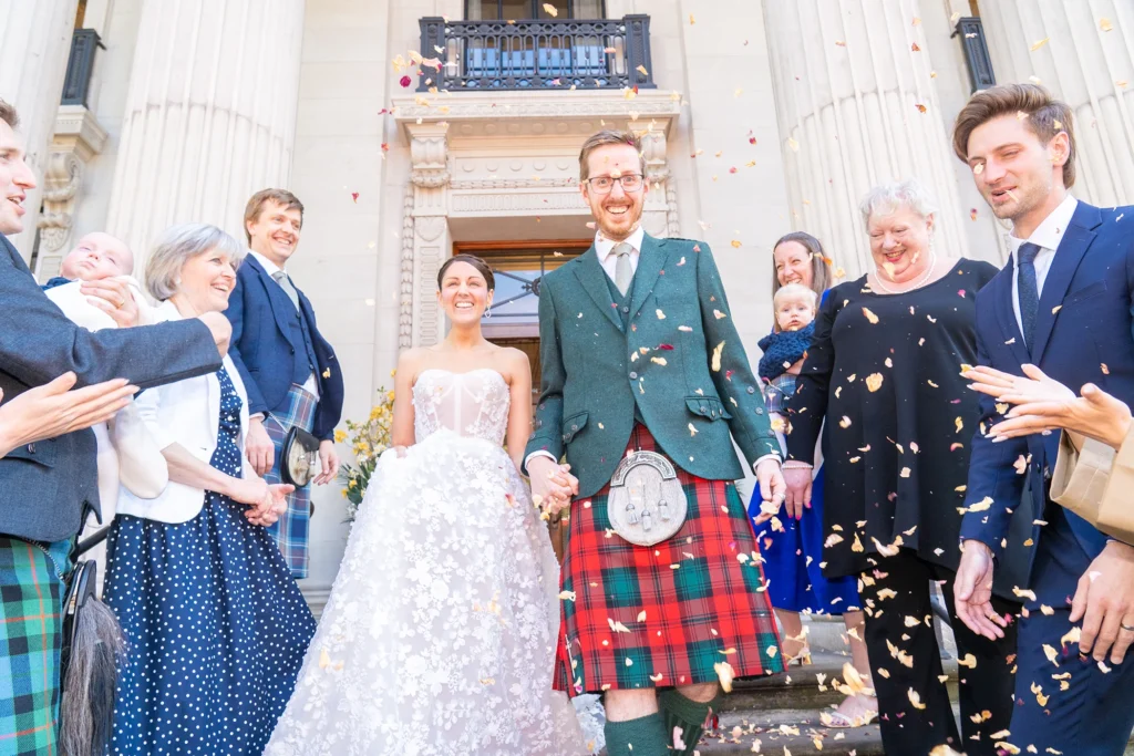 Guests cheering and throwing petals at newlyweds