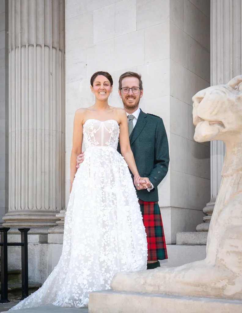 Bride and groom posing near stone lion