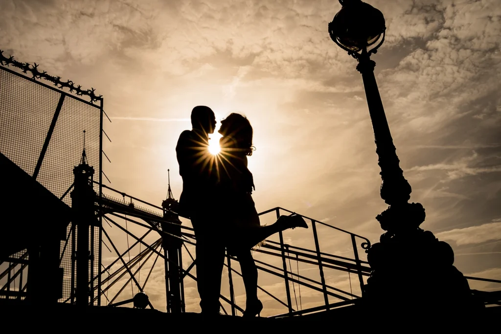 Romantic silhouette of bride and groom kissing at sunset near Chelsea Town Hall