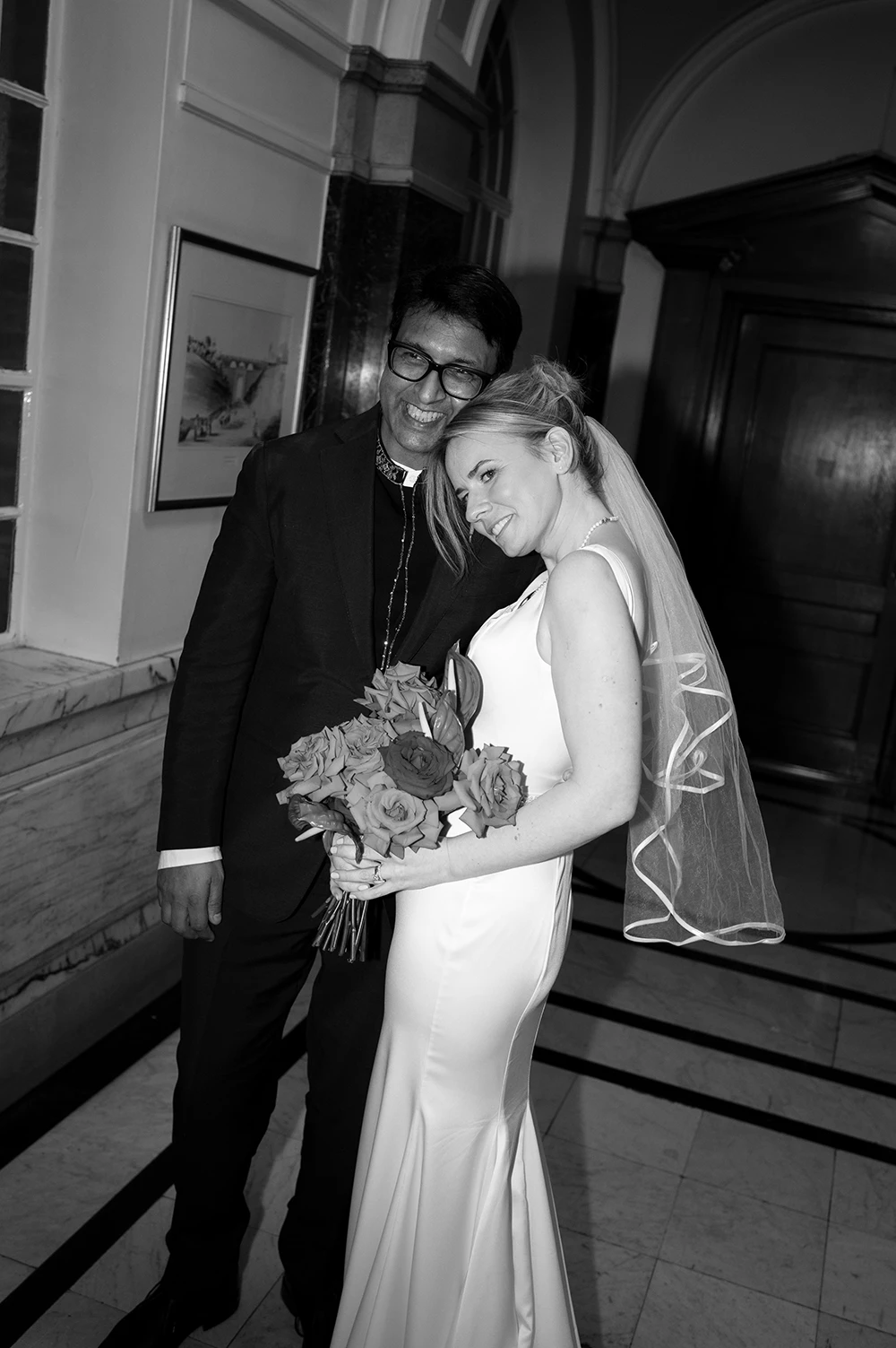 Black and white portrait of newlyweds smiling together after ceremony
