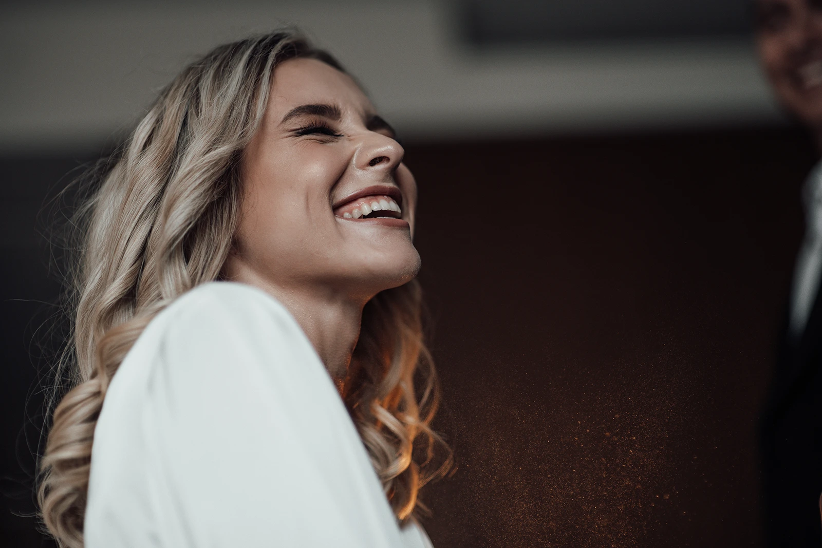 Close-up of a joyful, blonde woman smiling candidly, showcasing smooth, radiant, and youthful-looking skin.